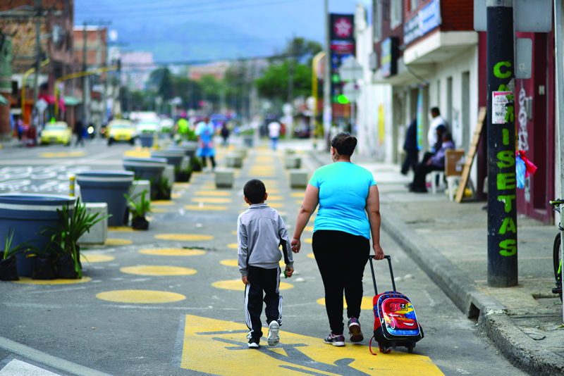 Niño y madre camino a la escuela con señalización